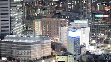 A cityscape at night with illuminated buildings, including a prominent building with a sign that reads "Humanics College".