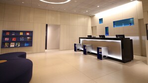 Un'area reception moderna con scrivania, posti a sedere e una parete dedicata a esposizione di libri.