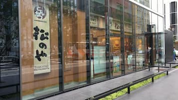 Un bâtiment moderne doté de grandes fenêtres en verre et d’une enseigne indiquant « Tonkatsu Matsunoya ».