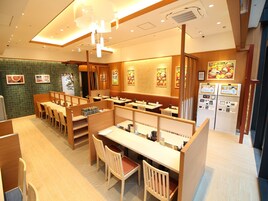 Un ristorante con sedute in legno, pareti in piastrelle e luci a soffitto.