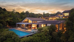 A modern house with a swimming pool, large windows, and a well-maintained garden. - The Point Villas (Taupo)