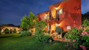 A two-story house with a balcony, surrounded by a well-maintained garden and a lawn. - Davinci Di Khao Yai (Pak Chong)