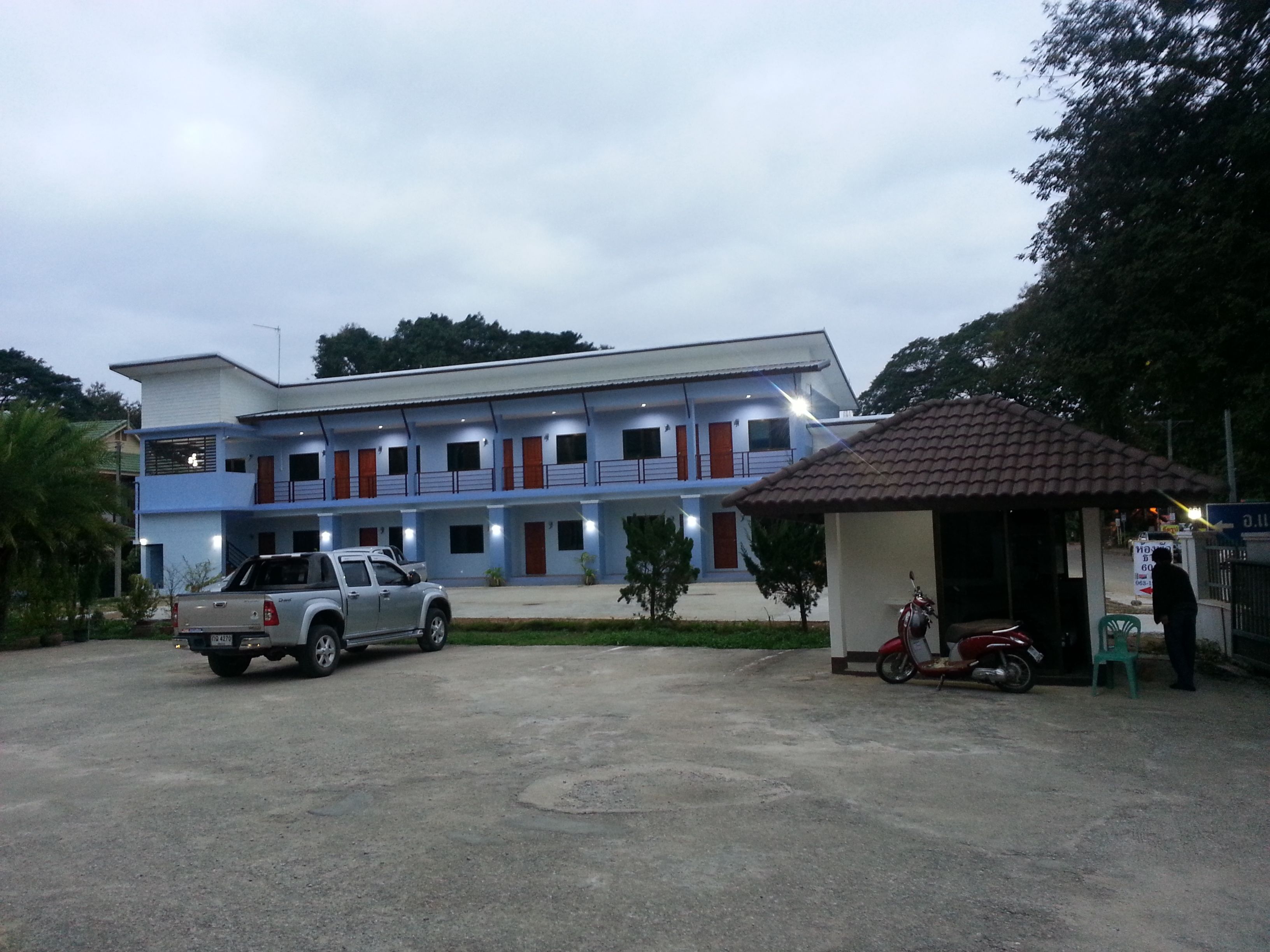 A two-story building with a flat roof and a small attached structure with a tiled roof.