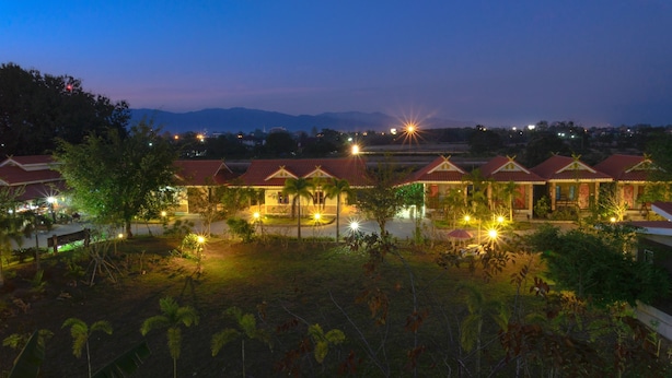 A resort with multiple buildings, each with a red roof and surrounded by greenery.