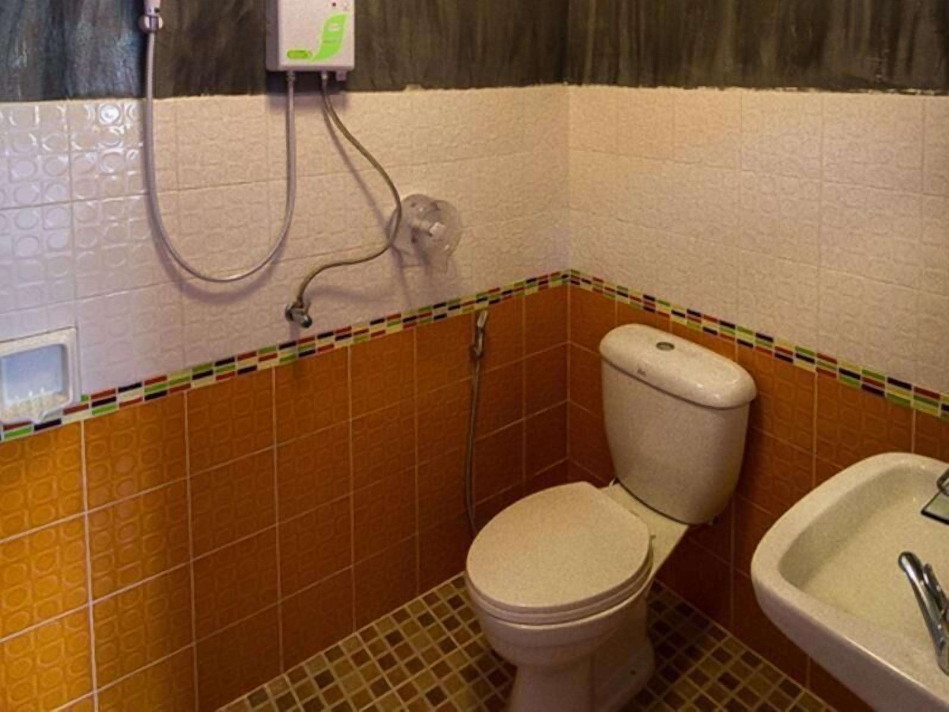 Un baño pequeño con inodoro, lavamanos y ducha.