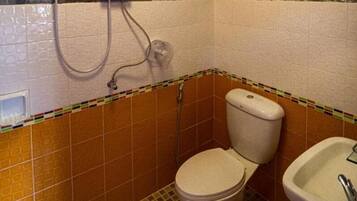 Un baño pequeño con inodoro, lavamanos y ducha.