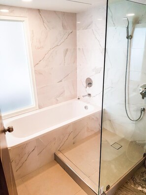 A bathroom with a bathtub and a glass-enclosed shower area.
