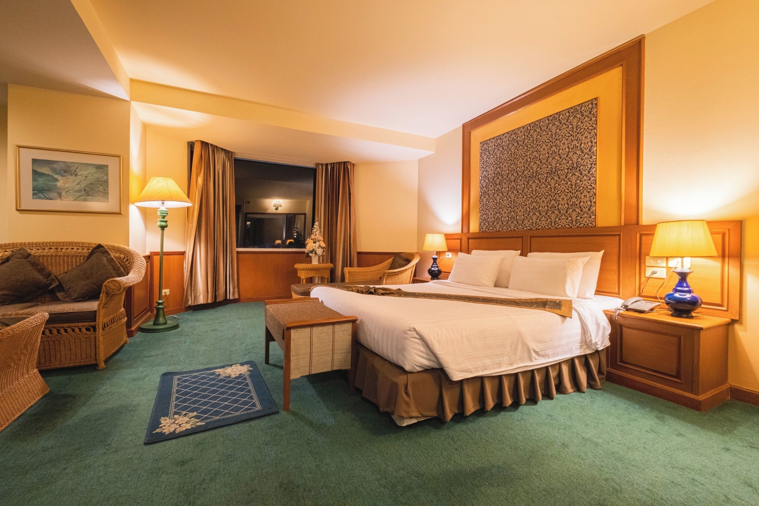 Une chambre d’hôtel avec un lit, un canapé, un bureau et une chaise.