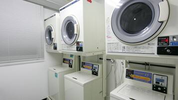 A laundry facility with multiple washing machines and dryers, including a 45kg CO/N washer and a 200kg dryer.