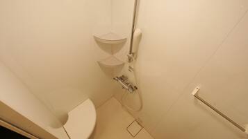 A small, white bathroom with a toilet, a shower, and a sink.
