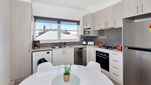 A modern kitchen with stainless steel appliances, a built-in oven, and a large window.