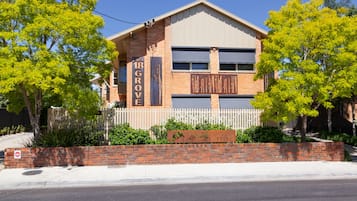 18 Grove features a charming two-story building with a flat roof and a white picket fence.