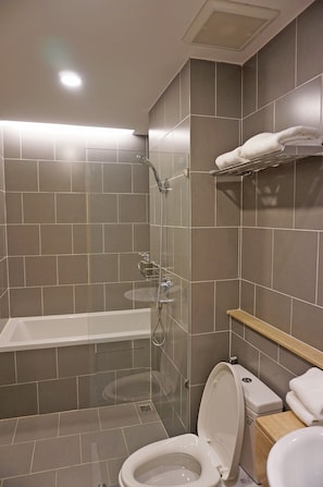 A modern bathroom with a bathtub, toilet, and shower. - Benri sriracha residence (Si Racha)