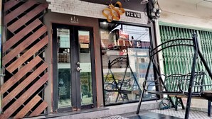 A storefront with a sign reading "HIVE 28" and a "WELCOME" sign above the door. - Hive28 (Bangkok)