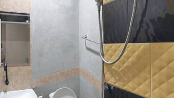 A bathroom with a toilet, a sink, and a shower.
