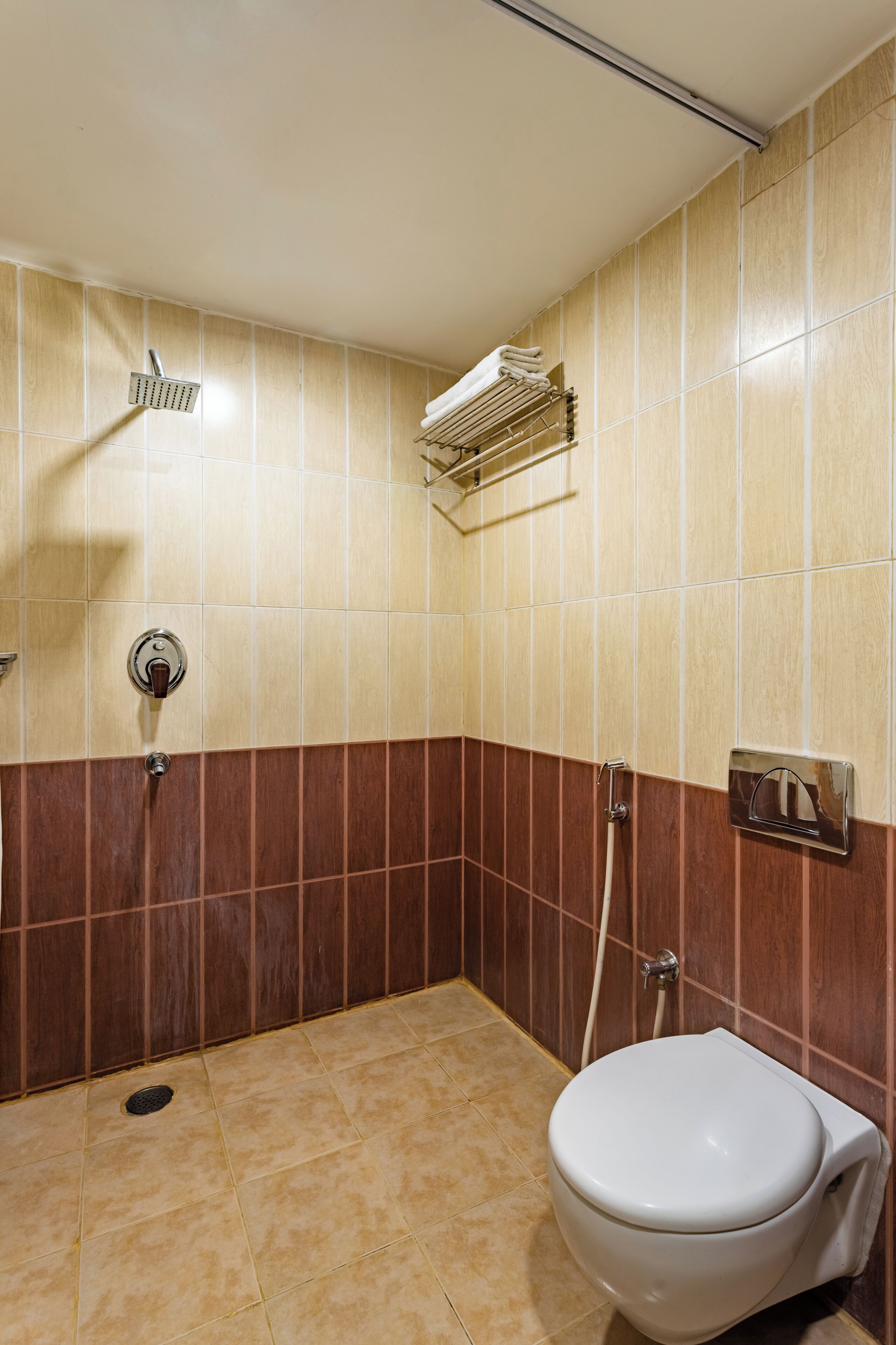 A bathroom with a shower, a toilet, and a towel rack.