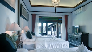 Ein Hotelzimmer mit zwei Betten, einem Fernseher, einem Schrank und Blick nach draußen.