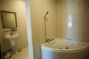 Un baño con bañera, lavabo y ducha.