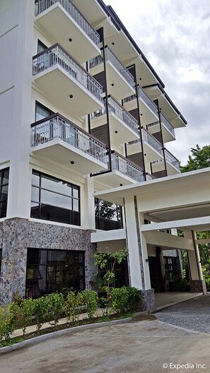 A multi-story building with balconies, large windows, and a stone facade. - Bravo Hotel and Resorts (Sibulan)