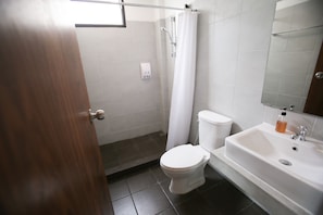 A bathroom with a toilet, a sink, and a shower. - Give Me 5 Hostel (Chiang Mai)
