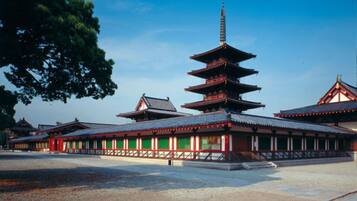 A traditional Japanese temple with a multi-tiered pagoda, a main hall with red and white walls, and a courtyard.