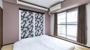 A hotel room with a bed, a window with curtains, and a wall with floral wallpaper. - Hotel SSK Osaka Naniwa (Osaka)