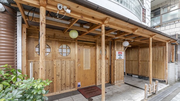 A traditional Japanese wooden building with a covered entrance, a sign indicating it is a hotel, and a small potted plant outside. - Hotel SSK Osaka Naniwa (Osaka)