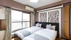A hotel room with two beds, a large window with curtains, an air conditioning unit, and a wall-mounted artwork. - Hotel SSK Osaka Naniwa (Osaka)