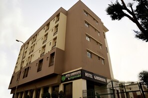 Un edificio de hotel de varios pisos con balcones y un cartel que dice 'Hotel Gandharva by peppermint'.