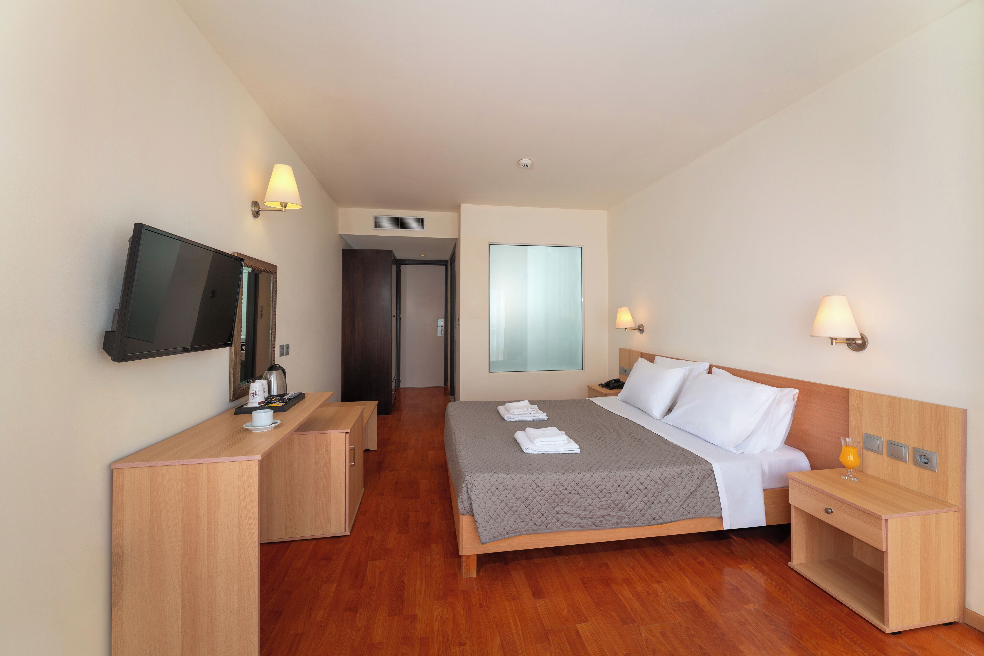 Une chambre d’hôtel avec un lit, un bureau, une télévision et une fenêtre.