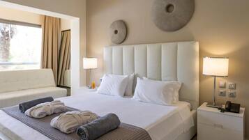 A hotel room with a large bed, two bedside lamps, a nightstand with a phone, and a window with curtains.