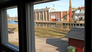 Uitzicht op een gebouw met grote ramen en een waterpartij ervoor.