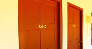 Two wooden doors with the words "SAND" and "WIND" on them. - Baywatch Beach Resort (Ambalapuzha)