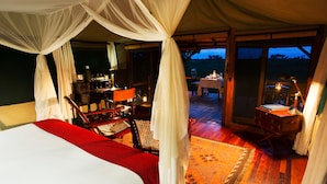 A tented room with a bed, chairs, a table, and a view of the outdoors. - Selinda Camp (Selinda Reserve)