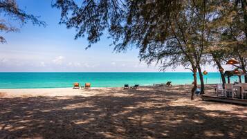 On the beach, sun-loungers, beach towels, surfing
