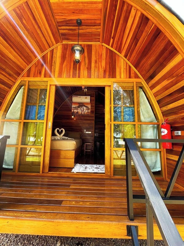A wooden cabin with a curved roof, a wooden staircase leading to a door, and a heart-shaped decoration on the floor. - Mumsa Beach Resort & Restaurant (Thap Sakae)