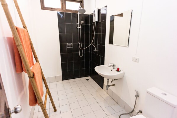 A bathroom with a shower, sink, and toilet.