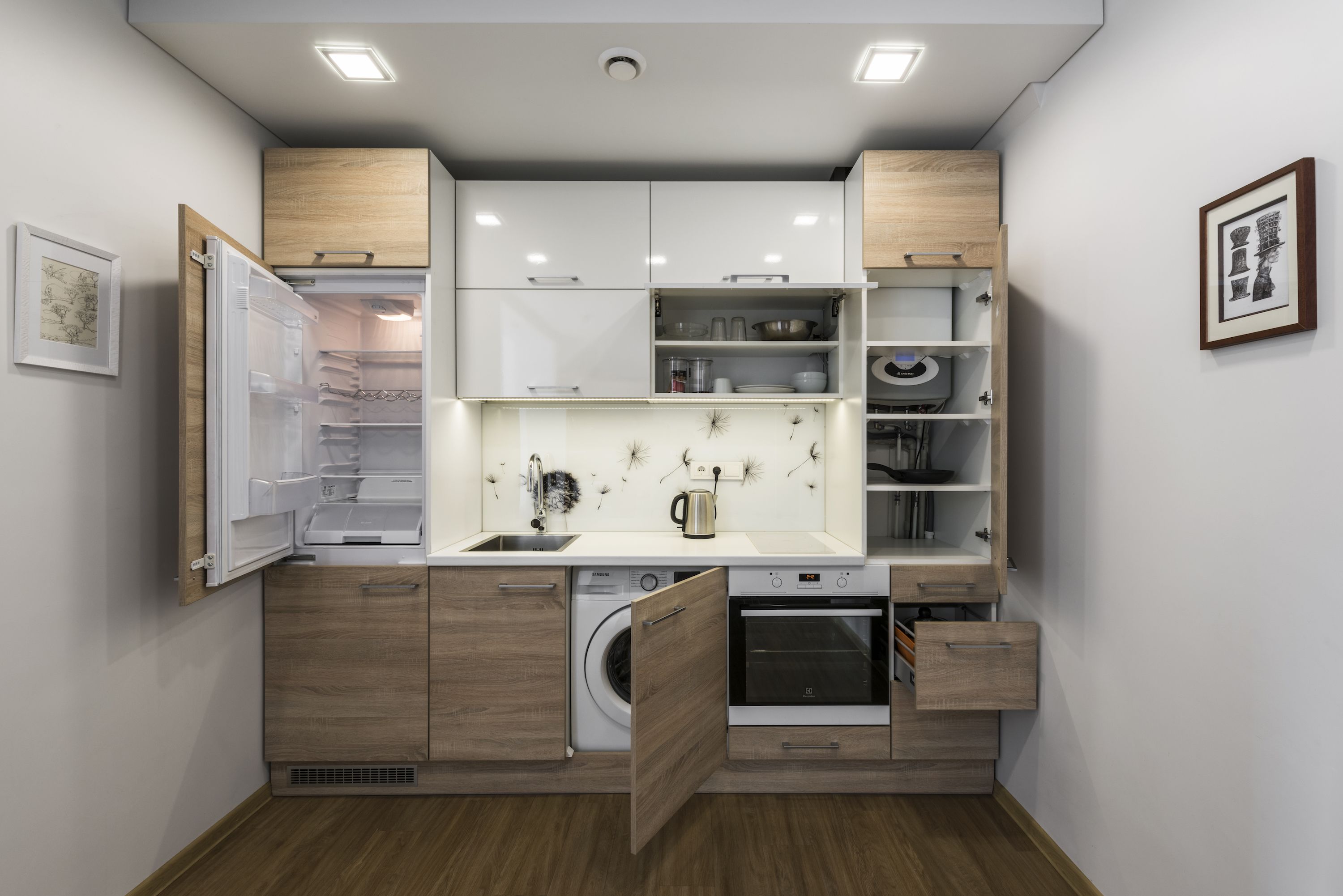 A compact kitchen with built-in appliances, wooden cabinetry, and a small countertop.