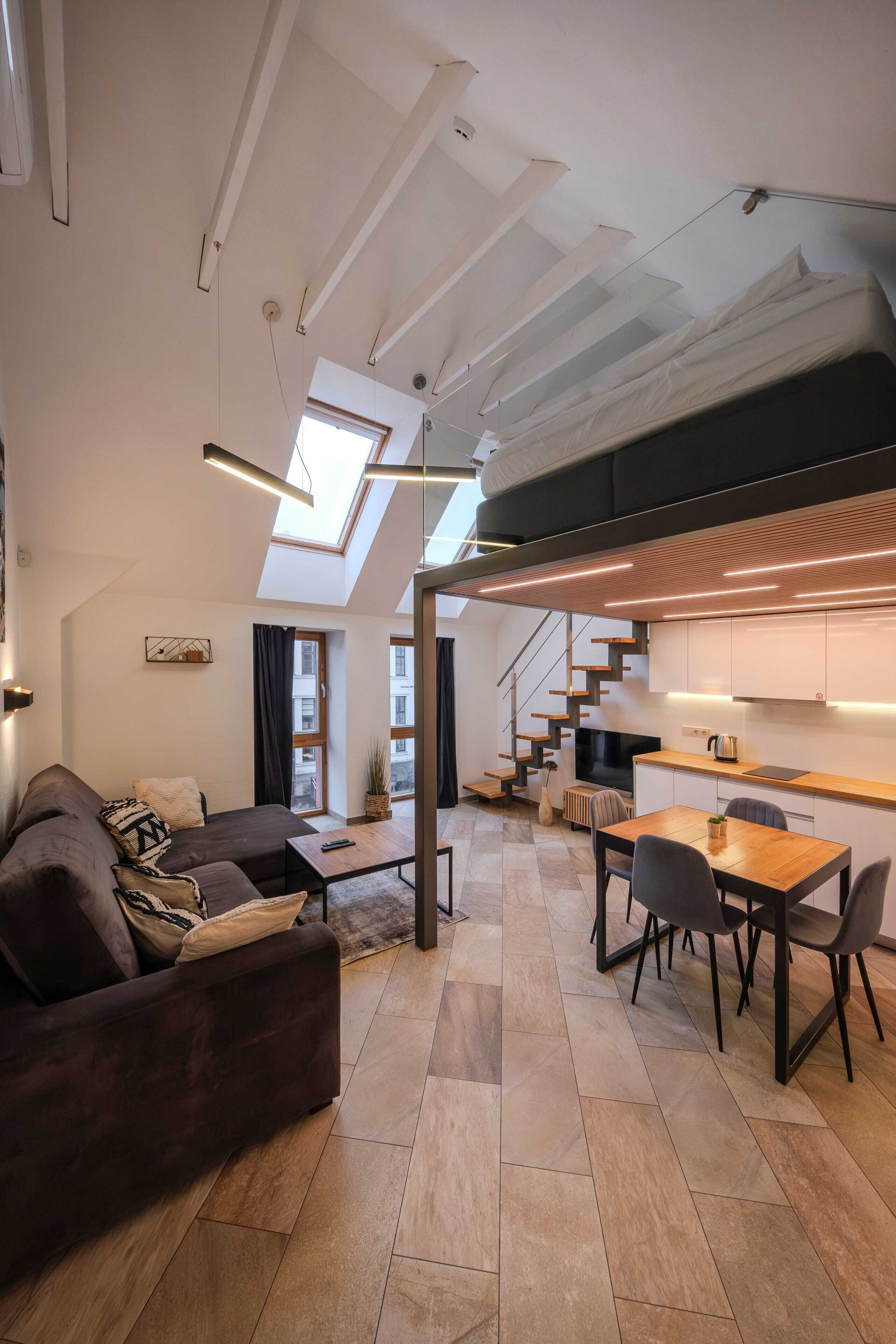 Un interno moderno con un divano, un tavolo da pranzo e una scala che conduce a un piano superiore.