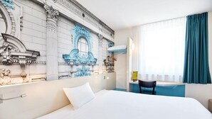 A hotel room with a large bed, a desk, and a decorative wall mural. - B&B Hotel Łódź Centrum (Lodz)