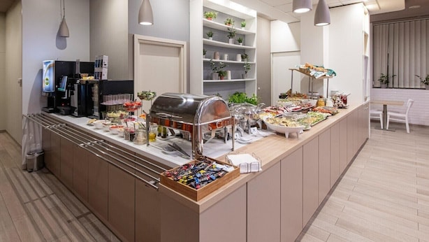 A buffet setup with a coffee machine, salad bar, and various food items. - B&B Hotel Łódź Centrum (Lodz)