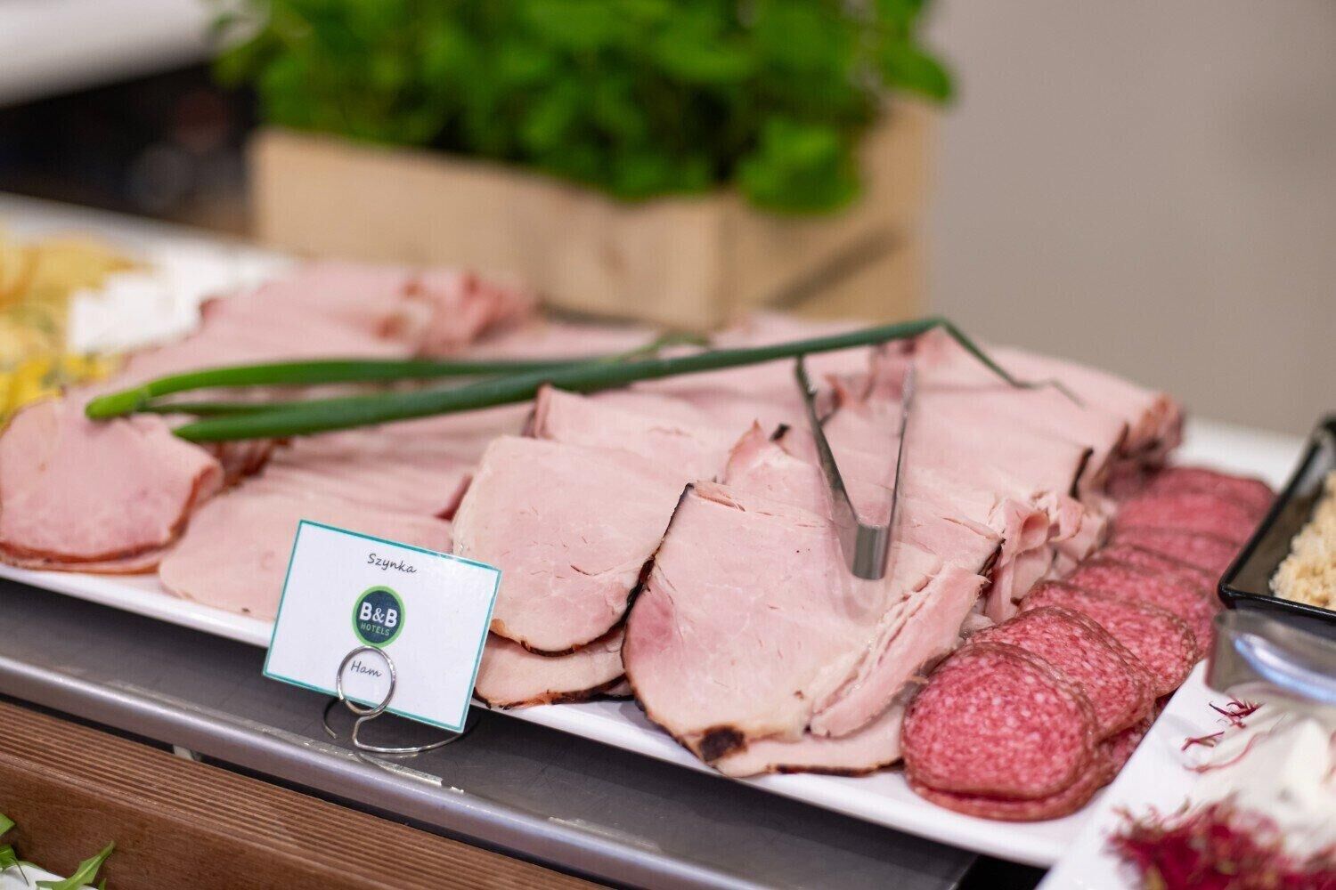 A buffet with sliced meats and garnishes, including a sign for B&B HOTELS.