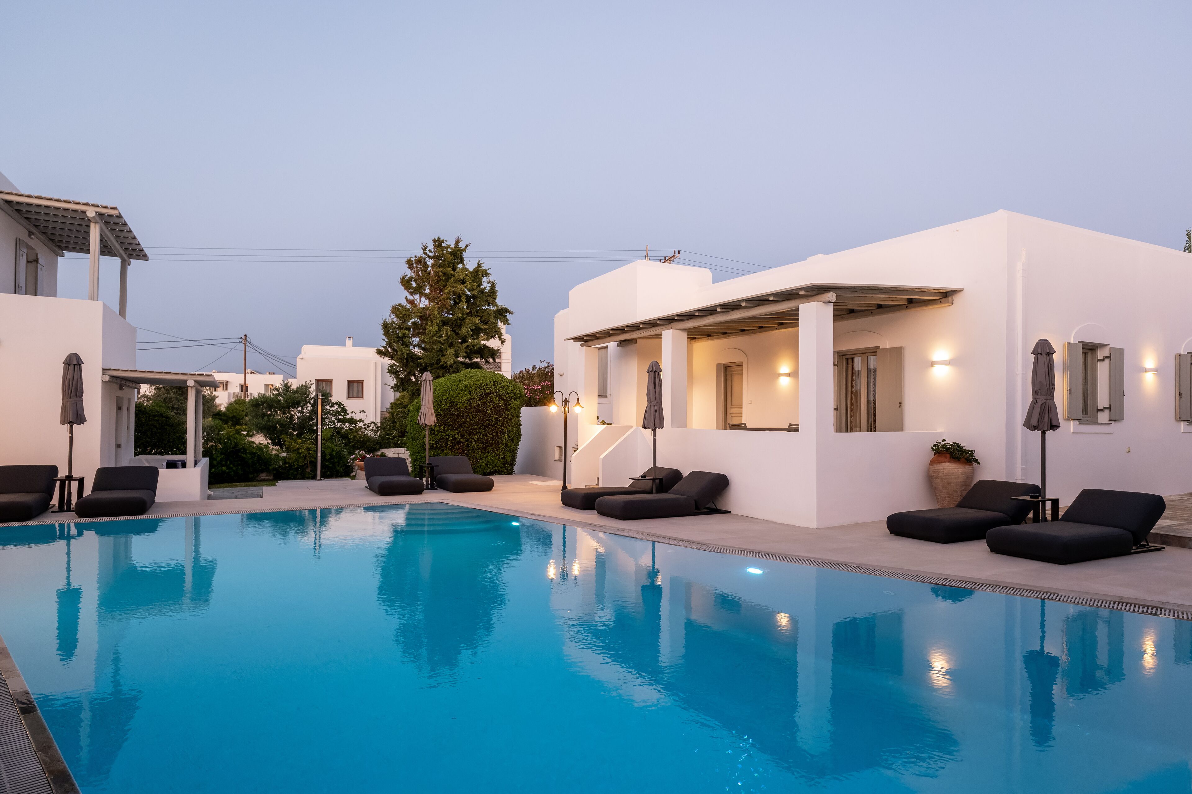 A modern pool area with lounge chairs and a clear blue pool.