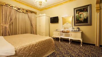 Habitación de hotel con una cama grande, un armario, un tocador con espejo, un televisor y un cuadro en la pared.