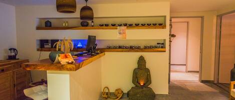 Eine moderne Küche mit Bar, einer Buddha-Statue und einem Esstisch mit einem Teller Essen.
