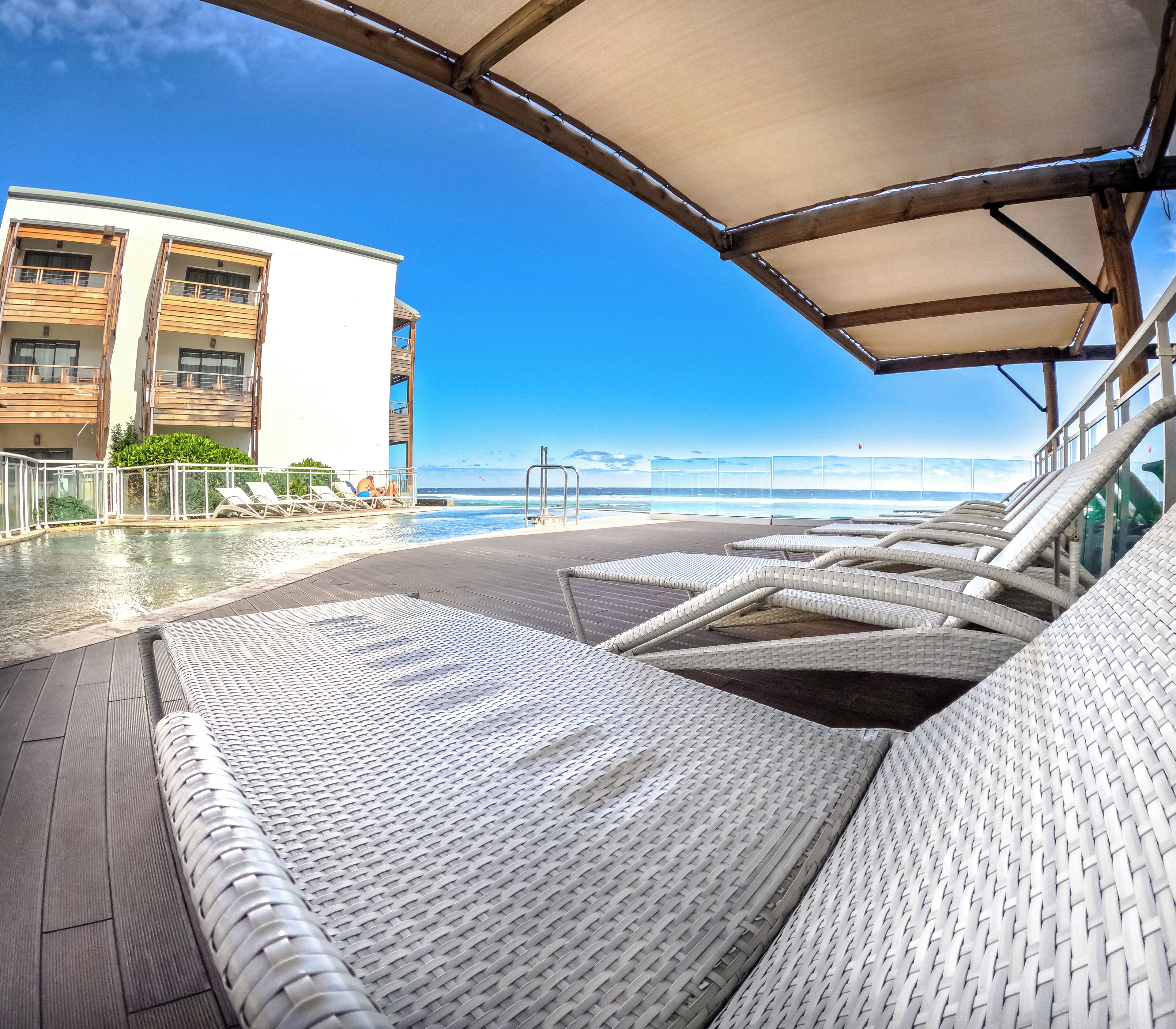 Una piscina al aire libre, sillones reclinables de piscina