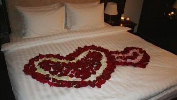 A bed with a heart-shaped arrangement of red and white flowers. - Hotel Al-Khalil Machava (Matola)