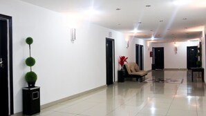 A modern hotel corridor with a clean, tiled floor, a reception desk, and a seating area. - Hotel Al-Khalil Machava (Matola)