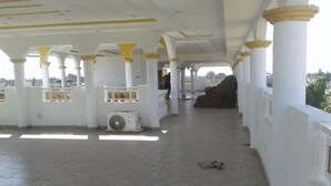 Un espacio interior con columnas blancas y suelo de baldosas.