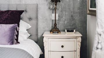 Un dormitorio con una cama, una mesita de noche con lámpara y un reloj de pared.